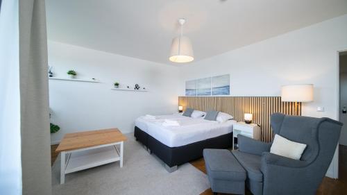 a hotel room with a bed and a chair at Favorite Stays - Suite And More - Neuss in Neuss