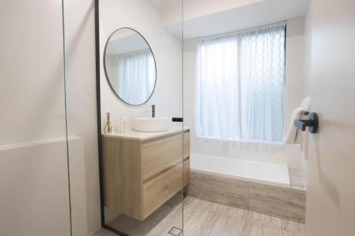 a white bathroom with a sink and a mirror at Family Retreat in Perth