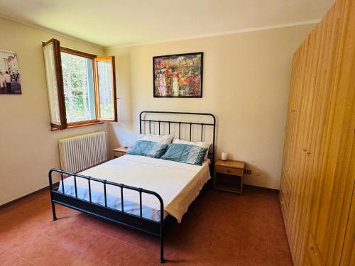 a bedroom with a bed with blue pillows at Casa Lenzi Porretta in Porretta Terme