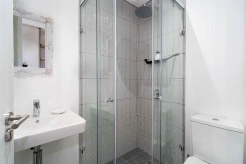 Un baño con ducha, lavabo e inodoro. en Apartment in Seapoint, en Ciudad del Cabo