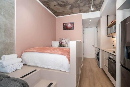 Un dormitorio pequeño con una cama y un televisor. en Apartment in Seapoint, en Ciudad del Cabo