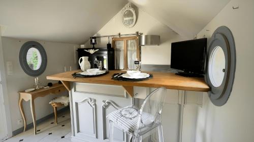 a kitchen with a counter and a chair in a room at L'Écrin Gustavien in Bruz