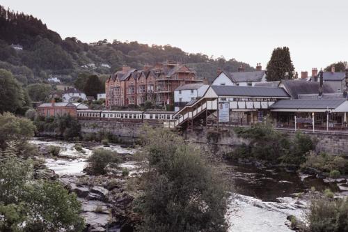 ランゴレンにあるStylish and spacious four-bedroom cottage by the river Eco-friendly hot tub, cozy open fireplace Beautiful viewの川沿いの駅のある町