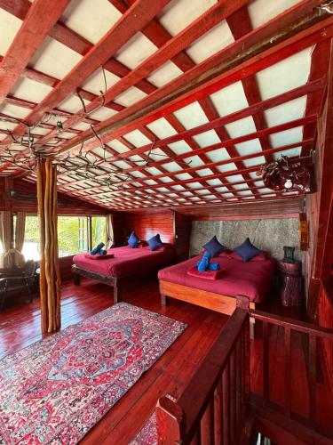 a room with two beds and a wooden ceiling at Mai Pen Rai Bungalows in Than Sadet Beach