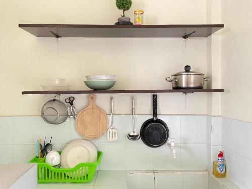 a kitchen with shelves and utensils on the wall at Carcar Guesthouse in Barraca