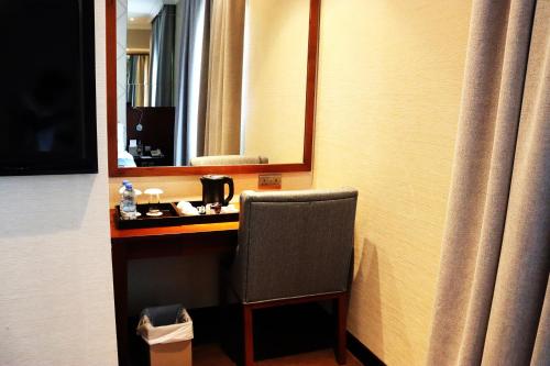 a room with a desk with a mirror and a chair at Raviz Center Point Hotel in Dubai