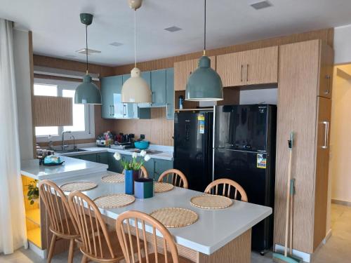 a kitchen with a table with chairs and a black refrigerator at Jefaira Senior Chalet, 4 bedrooms with roof in Jalāl