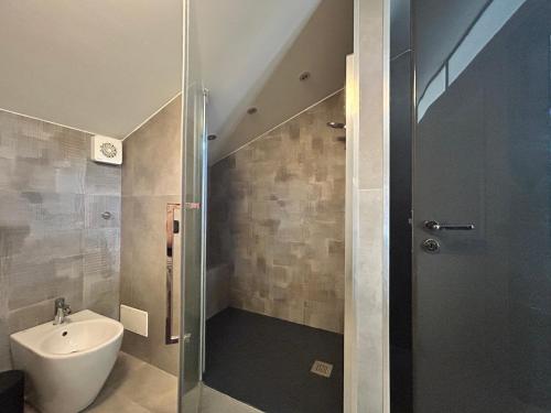 a bathroom with a shower and a toilet and a sink at Attico nel Centro di Novara in Novara