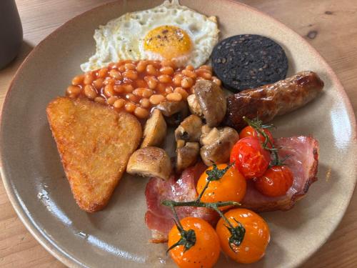 a plate of breakfast food with eggs beans and toast at Rooms at the Inn in Trotton