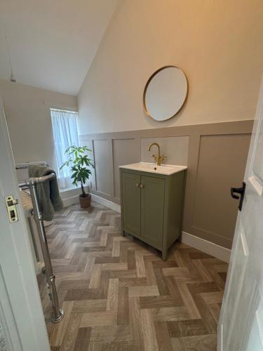 a bathroom with a sink and a mirror on the wall at Rooms at the Inn in Trotton