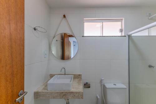 a bathroom with a sink and a mirror at Apt em Condomínio pé na areia - Praia da Perola in Ilhéus