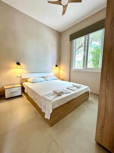 a bedroom with a large bed and a window at Golden Beach Apartments in Chrysi Ammoudia