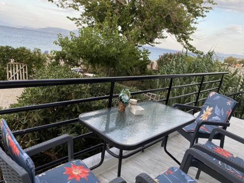 a table and chairs on a balcony with the ocean at Seaside Apartment Kato Diminio in Káto Dhiminión