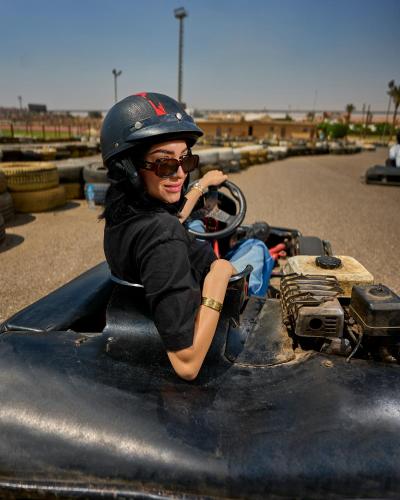 a woman wearing a helmet sitting on a toy car at Ramage Hotel & Resort in Cairo