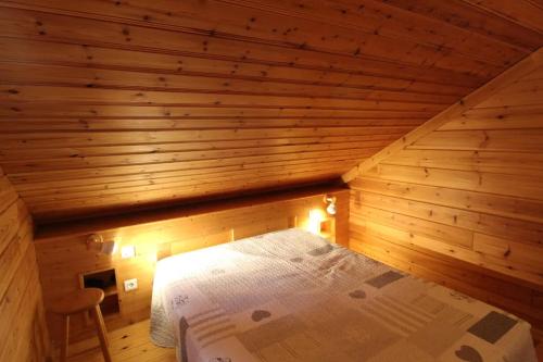 a bedroom with a bed in a wooden room at Chalet des Brimbelles, séjour au cœur de la nature au cœur de la vallée des lacs in Xonrupt-Longemer