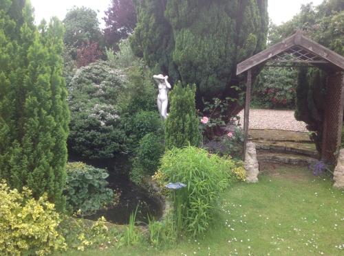 a statue of a woman standing in a garden at The Greyhound - Historic former Inn in Glemsford