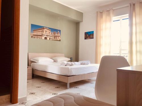 1 dormitorio con 1 cama y un edificio en la pared en La Madonnina, en Noto