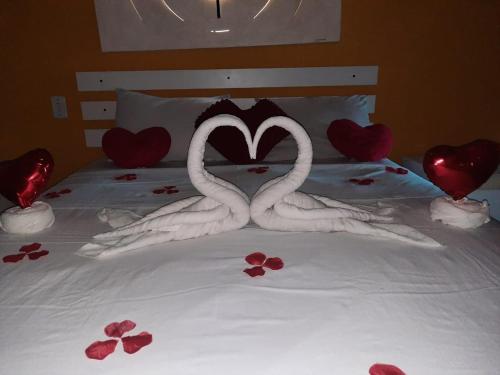 two swans making a heart shape on a bed at Pousada Bon Vivant in Cabo Frio