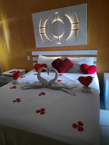 a bed with two birds made out of hearts at Pousada Bon Vivant in Cabo Frio