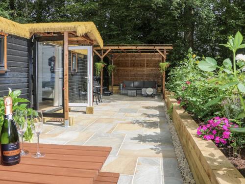 a patio with a couch and a pergola at Charltons Hollow Cabin in Haywards Heath