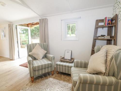 a living room with two chairs and a couch at Charltons Hollow Cabin in Haywards Heath