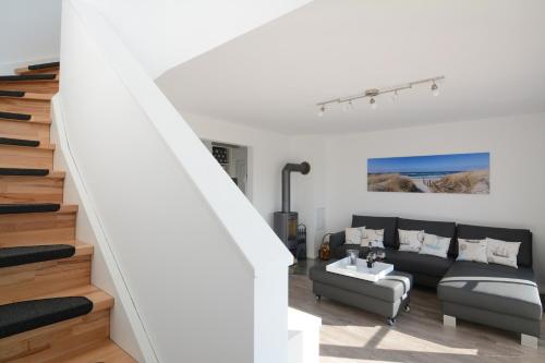 a living room with a couch and a staircase at Ferienwohnung Wilbur Olpenitz in Olpenitz