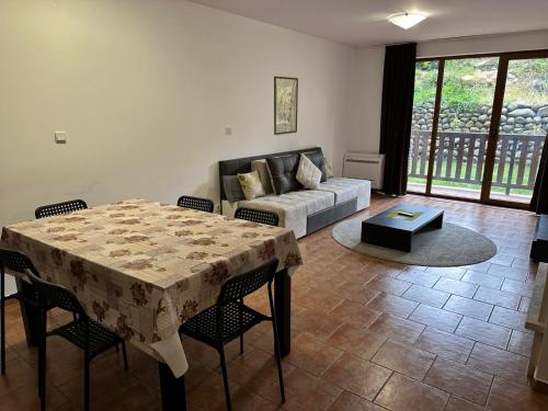 a living room with a table and a couch at Private apartment in Prespa in Bansko