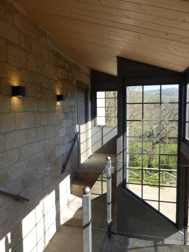a room with a stone wall and a staircase with windows at Pietre di Fiume in Apice