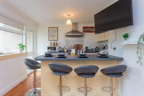 a kitchen with a island with bar stools at Free Parking - City Centre - 3 Bedrooms - 5 Guests in Edinburgh