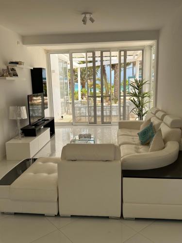 萨尔雷Villa Cristina Alojamento, Praia de Chaves, Boa Vista, Cape Verde, WI-FI的配有白色家具和大窗户的客厅