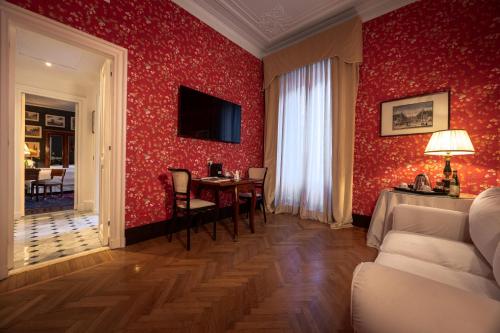 a room with a table and a red wall at Grand Hotel Plaza in Rome