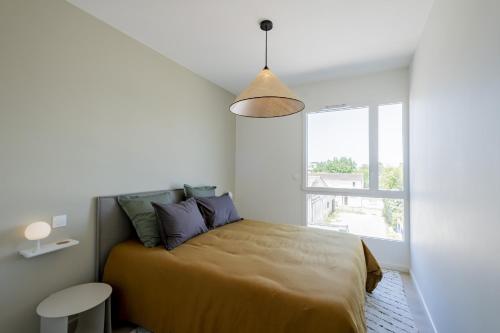une chambre avec un lit et une grande fenêtre dans l'établissement Spacious 4BR with Lovely Balcony, à Bordeaux