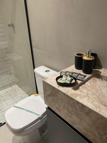 a bathroom with a toilet and a counter with a sink at Flat Intermares in Cabedelo