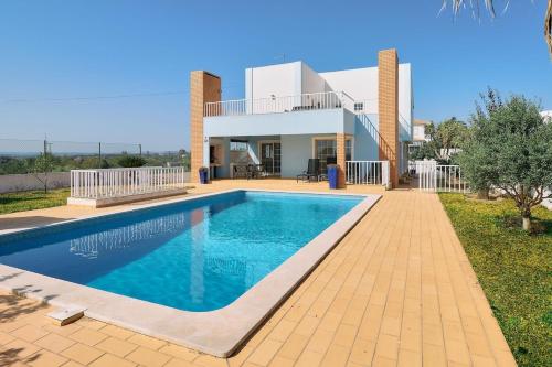 a villa with a swimming pool in front of a house at Casa Casimiro mit privaten beheizten Pool in Pêra