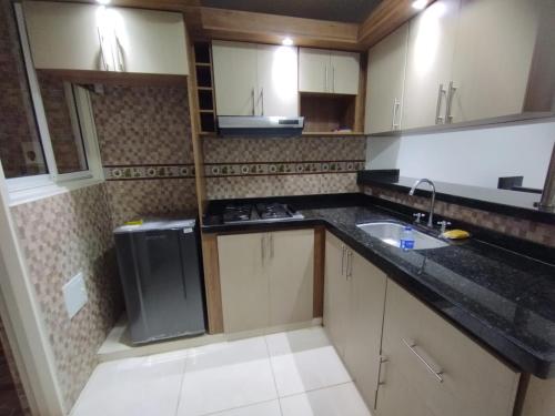 a small kitchen with a sink and a stove at Apartamento amoblado y piscina fuera del alojamiento in San Gil