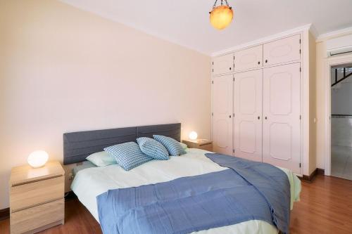 a bedroom with a large bed with blue pillows at Casa Casimiro mit privaten beheizten Pool in Pêra