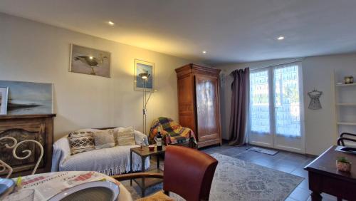 un salon avec un canapé et une table dans l'établissement Saint Georges de Didonne - PETITE MAISON avec son petit coin de paradis extérieur, à Saint-Georges-de-Didonne