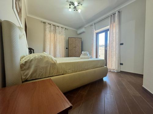 a bedroom with a bed and a large window at B&B Anna in Marigliano