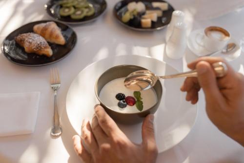 een persoon die een kom eten op een tafel bij Hotel Patrizia in Tirolo