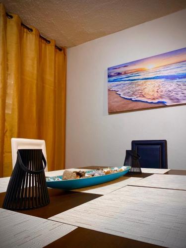 a table with two chairs and a blue surfboard on it at Casita Velera in Lajas