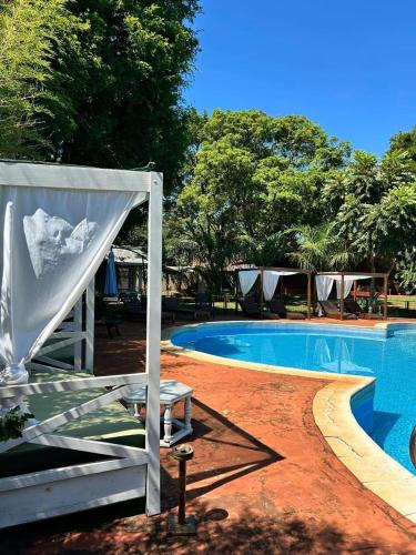 a large swimming pool with a tent next to it at YVYRA Hotel & Cabañas in La Porteña
