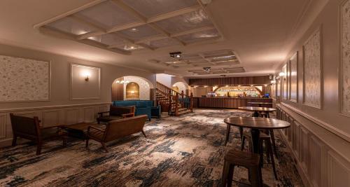a lobby with tables and chairs in a building at Roker Hotel BW Premier Collection in Sunderland