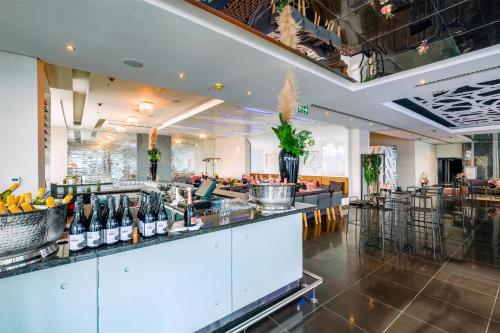 a restaurant with a bar with bottles of wine at Radisson Blu Gautrain Hotel, Sandton Johannesburg in Johannesburg