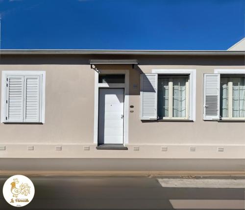a house with a white door and windows at La Pavoncella in Oristano