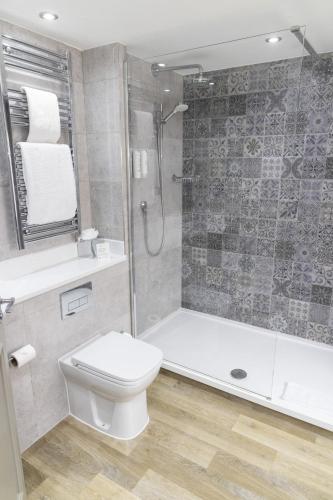 a bathroom with a shower and a toilet and a sink at Garner Hotel Nottingham City Centre by IHG in Nottingham