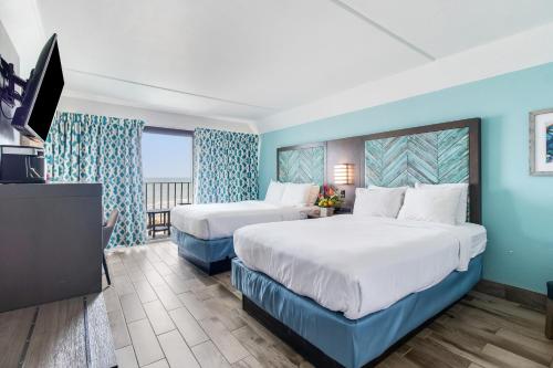 派恩诺尔肖尔斯Crystal Coast Oceanfront Hotel的一间有两张床和一台平板电视的酒店房间