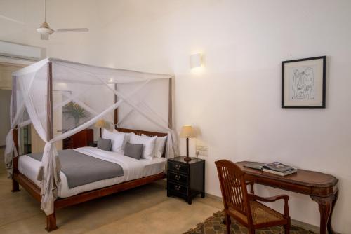 a bedroom with a canopy bed and a desk at No 50 Lighthouse Street in Galle