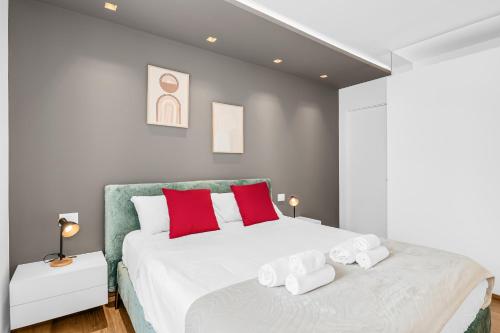 a bedroom with a large white bed with red pillows at Luxury Brera apartment - Corso Como 9 in Milan