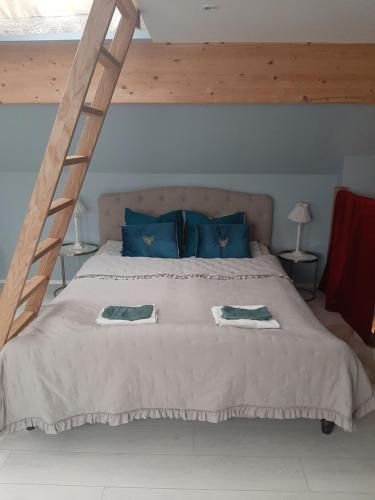 Un dormitorio con una cama grande con almohadas azules y una escalera. en Kuninga Holiday Apartment, en Pärnu