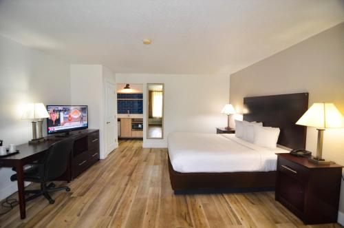 a hotel room with a bed and a desk and a television at Hotel SonoHotel IDrive District in Orlando